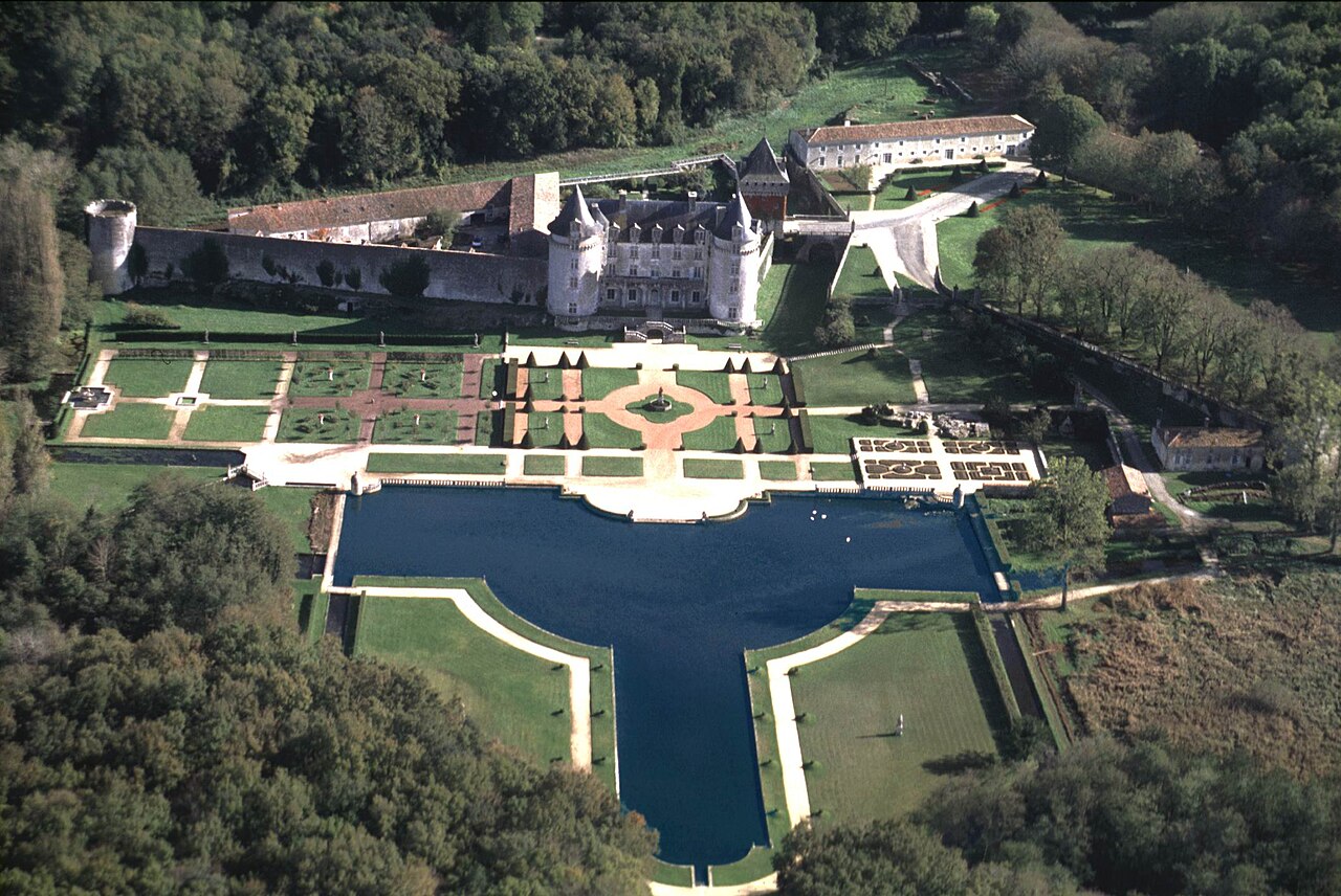 Vue aérienne du château de la Roche Courbon à Saint-Porchaire, forteresse médiévale entourée de jardins à la française et de forêt
