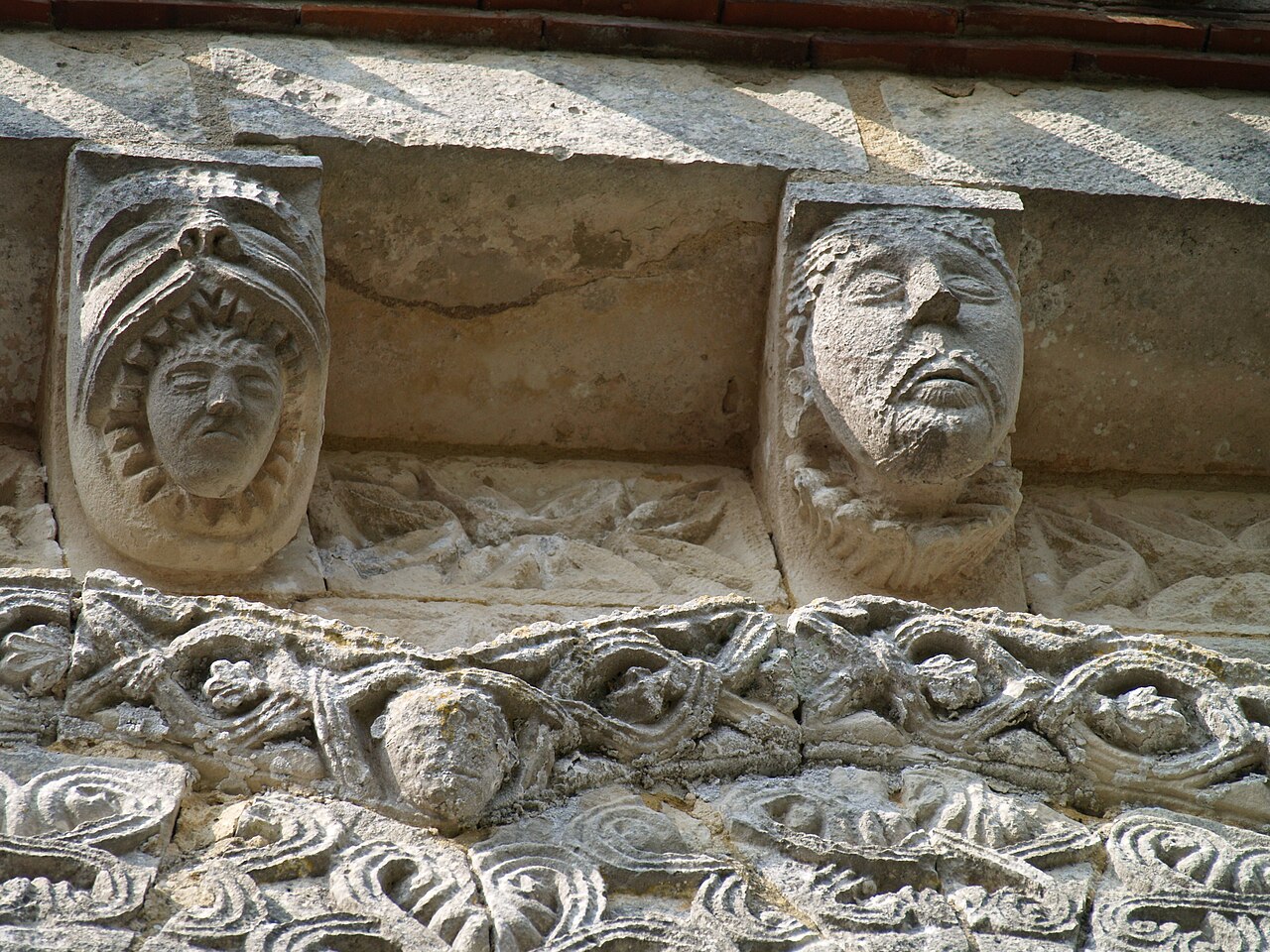 Modillons sculptés sous la corniche de l'abside heptagonale, église Notre-Dame de Rioux