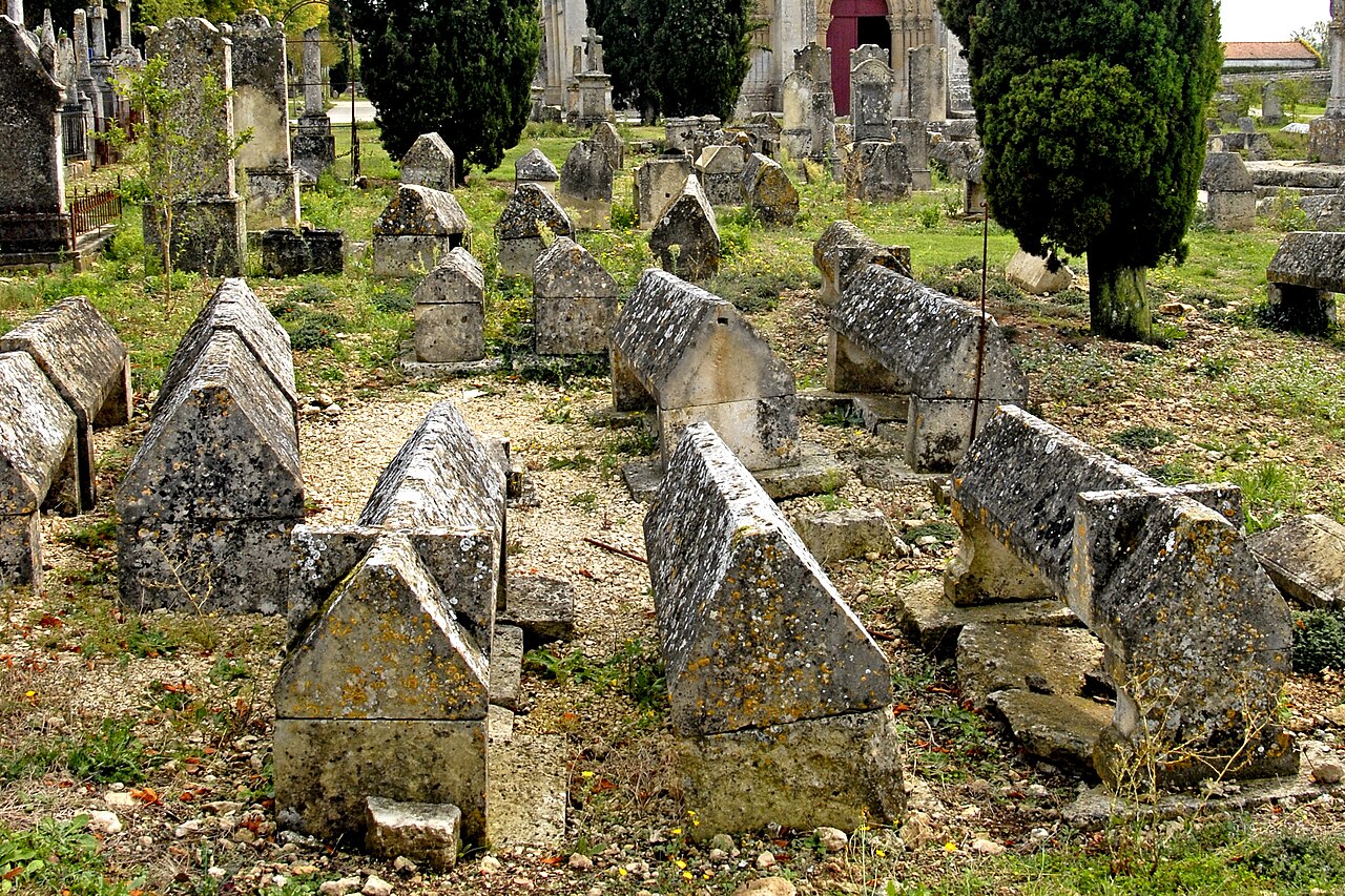 Église Saint-Pierre d'Aulnay vue depuis le cimetière médiéval bordé de cyprès, Charente-Maritime