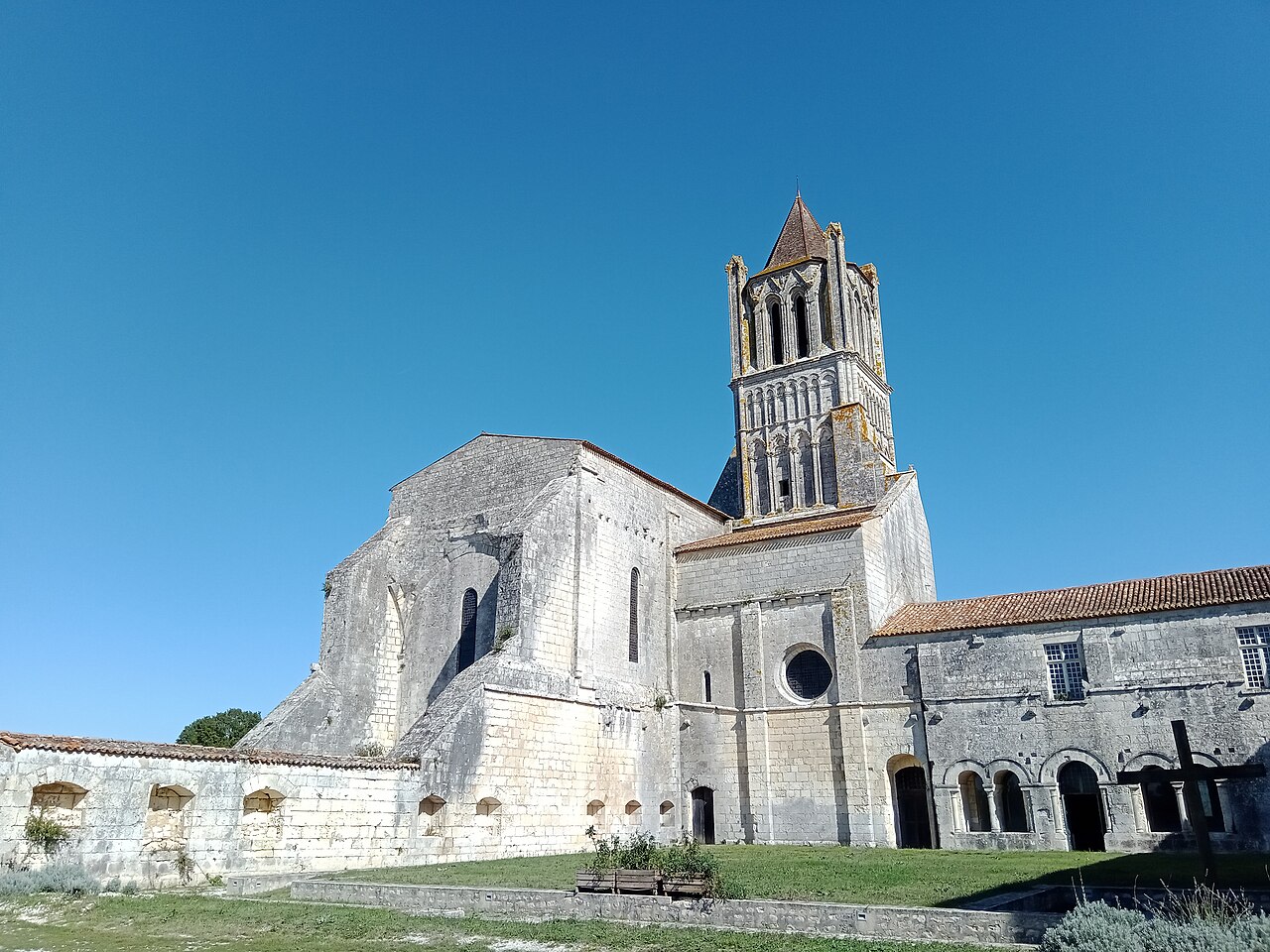 Parvis et entrée de l'abbatiale de Sablonceaux avec le portail baroque de 1788 et le noyer centenaire classé arbre remarquable